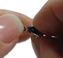 Hands pressing the cabochon into the setting